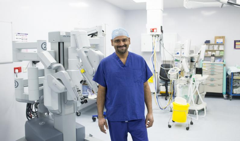Doctor in a room with da Vinci surgical robots