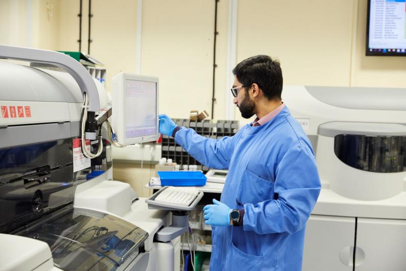 Staff member using machine in biochemistry laboratory