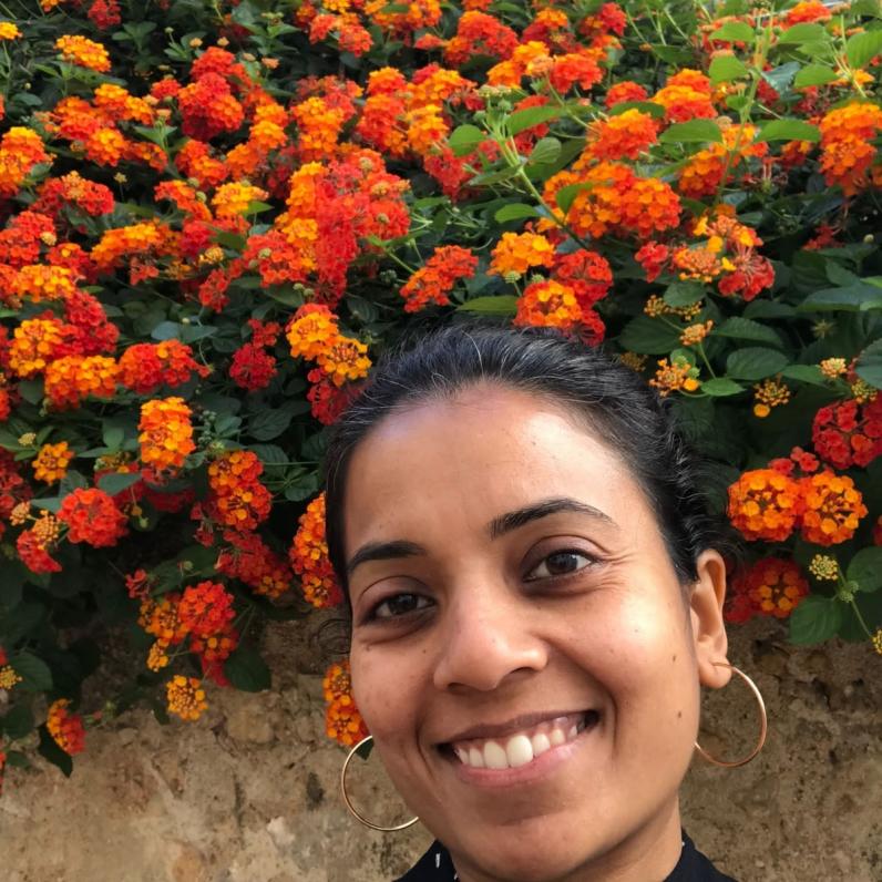 Woman stands in front of orange flowers