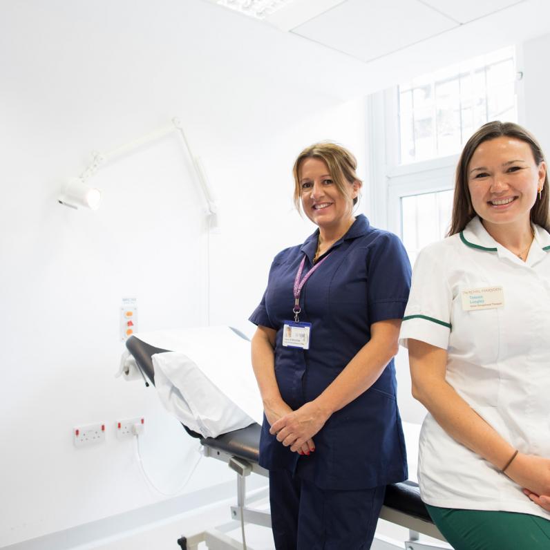 Tamsin Longley and Sarah Stapleton, the staff behind one of the innovations, smile while posing next to a phsyio bed at The Royal Marsden hospital